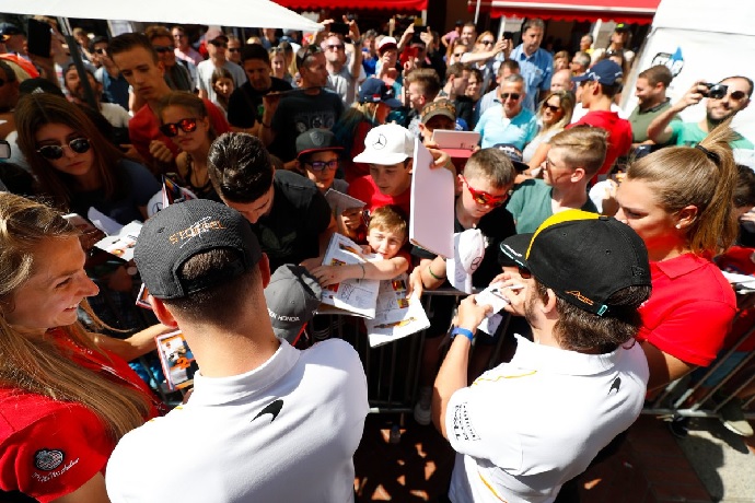 Alonso y Vandoorne firmando autógrafos
