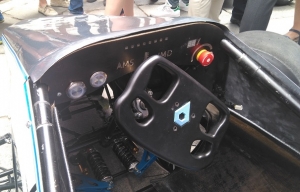 Cockpit del monoplaza eléctrico con el logo del equipo en el volante.
